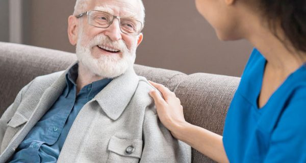 elderly man being comforted by a young nurse